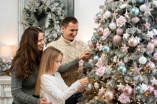 Vista frontal de la familia y el árbol de navidad.