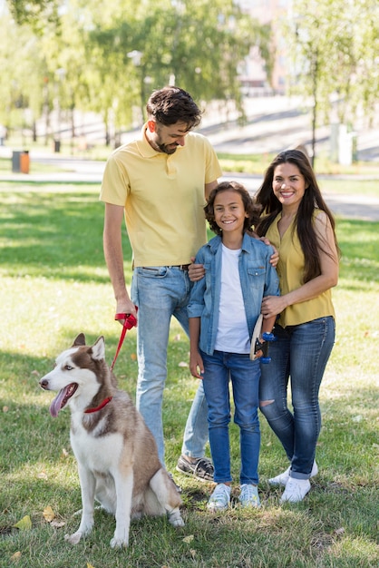 Vista frontal de la familia con niño y perro en el parque