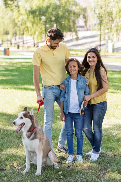 Vista frontal de la familia con niño y perro en el parque
