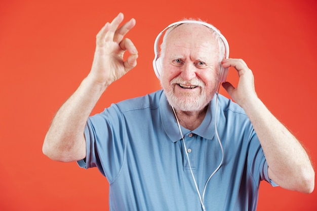 Vista frontal feliz anciano con auriculares