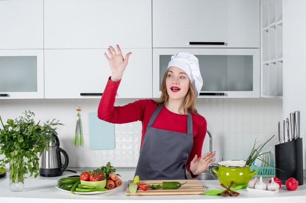 Vista frontal feliz chef mujer en sombrero de cocinero