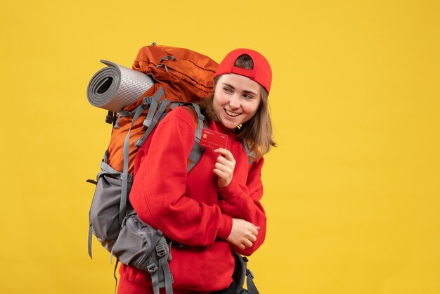 Vista frontal feliz excursionista mujer con mochila con tarjeta de crédito