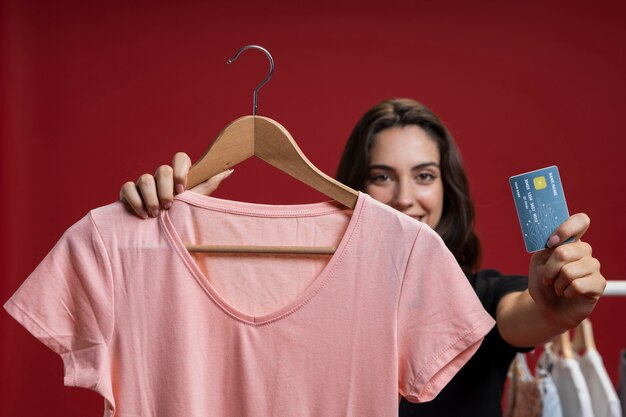 Vista frontal feliz mujer lista para comprar una camisa rosa