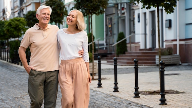 Vista frontal de la feliz pareja de ancianos dando un paseo por la ciudad