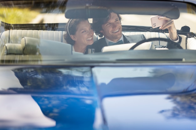 Vista frontal feliz pareja casada en coche