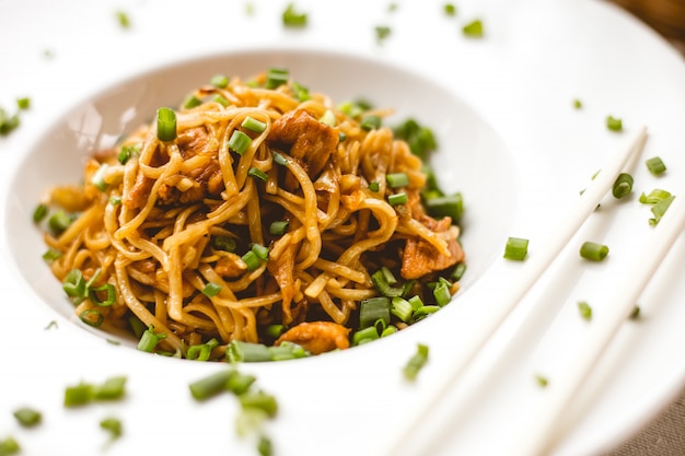 Vista frontal de fideos chinos en salsa con cebolla verde