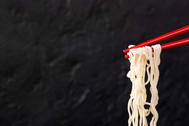 Vista frontal de fideos en palillos con espacio de copia