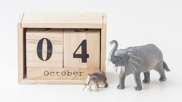 Vista frontal de figuras de elefantes con calendario de madera para el día de los animales