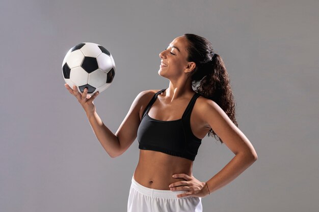 Vista frontal fit mujer sosteniendo bola