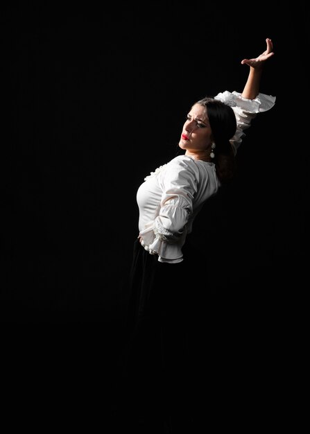 Vista frontal de flamenca bailando sobre un fondo negro