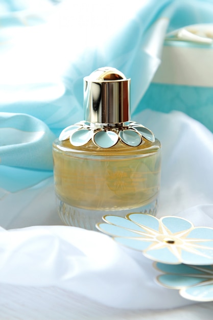 Vista frontal frasco de perfume con una flor de papel azul