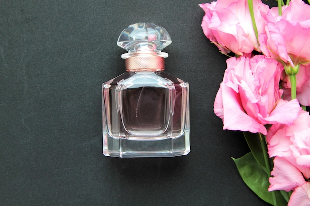 Vista frontal frasco de perfume con rosas rosadas
