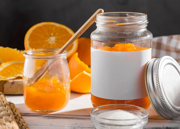 Vista frontal del frasco transparente con mermelada de naranja