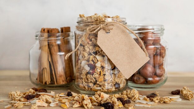 Vista frontal de frascos transparentes con cereales para el desayuno y etiqueta