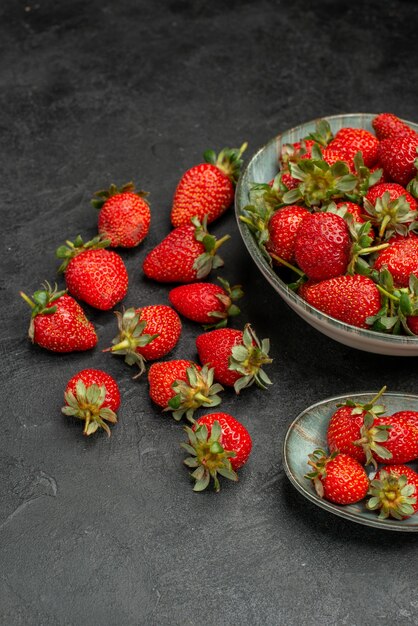 Vista frontal de fresas rojas frescas sobre un fondo gris jugo de árbol salvaje de bayas de color verano