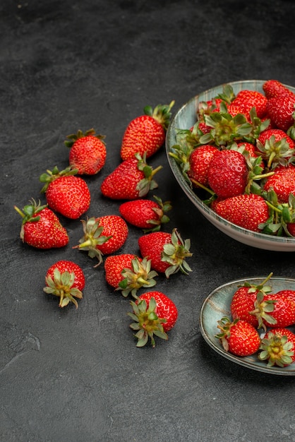 Vista frontal de fresas rojas frescas sobre un fondo gris jugo de árbol salvaje de bayas de color verano