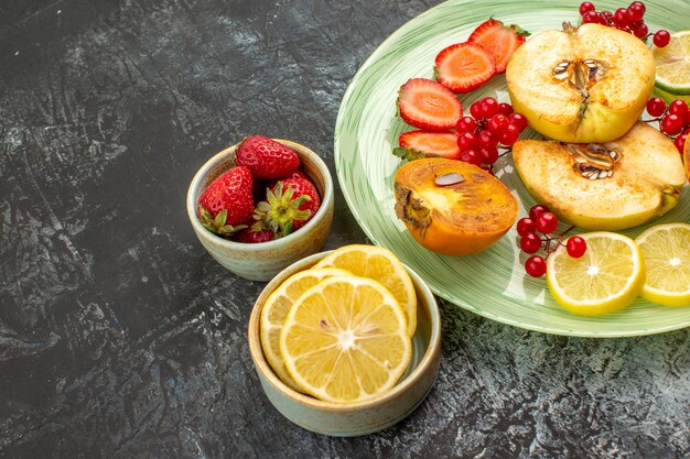 Vista frontal frutas frescas membrillos limones y otras frutas en mesa de luz