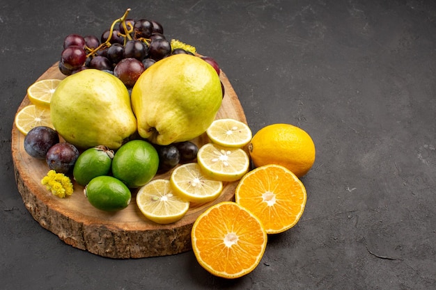 Vista frontal frutas frescas uvas rodajas de limón ciruelas y membrillos en el fondo oscuro árbol de plantas maduras de frutas frescas