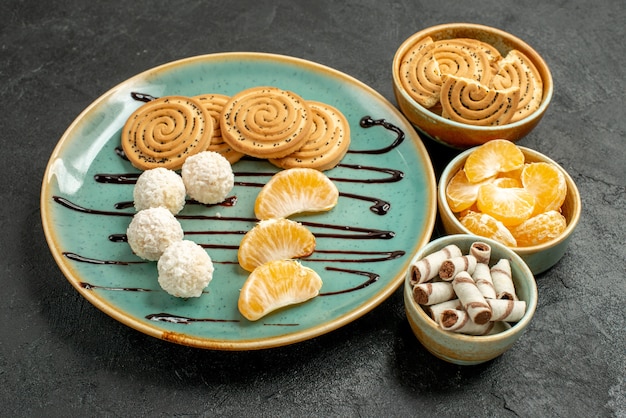 Vista frontal de las galletas de azúcar con caramelos de coco en la mesa gris galletas de galleta dulce
