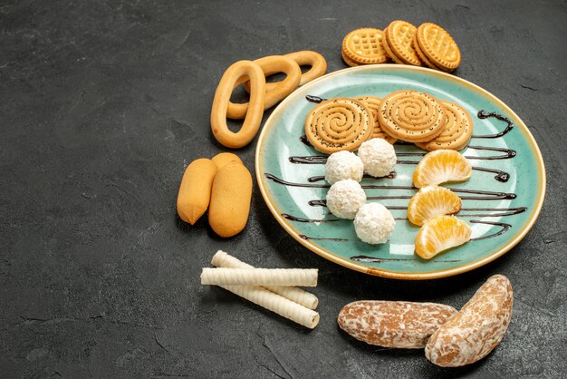 Vista frontal de las galletas de azúcar con galletas y dulces en la mesa gris pastel biscuit candy