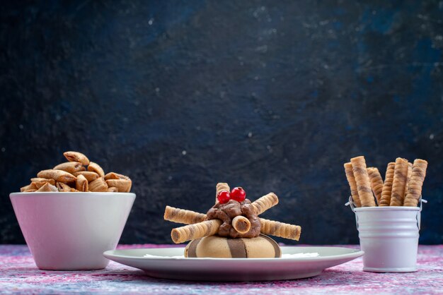 Vista frontal de galletas de chocolate junto con patatas fritas en la superficie oscura