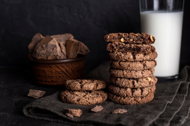 Vista frontal de galletas de chocolate con vaso de leche