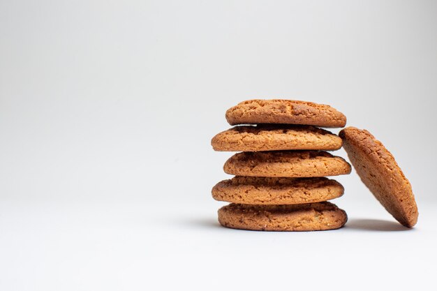 Vista frontal galletas dulces de arena en galleta blanca postre de azúcar pastel té