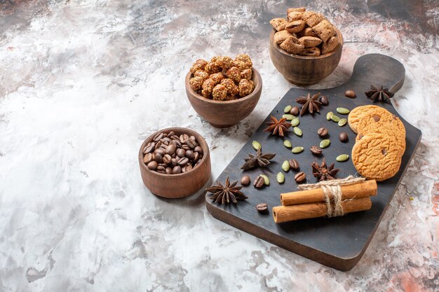 Vista frontal de galletas dulces con café y nueces sobre fondo claro, azúcar, té, galletas de color, pastel de cacao dulce