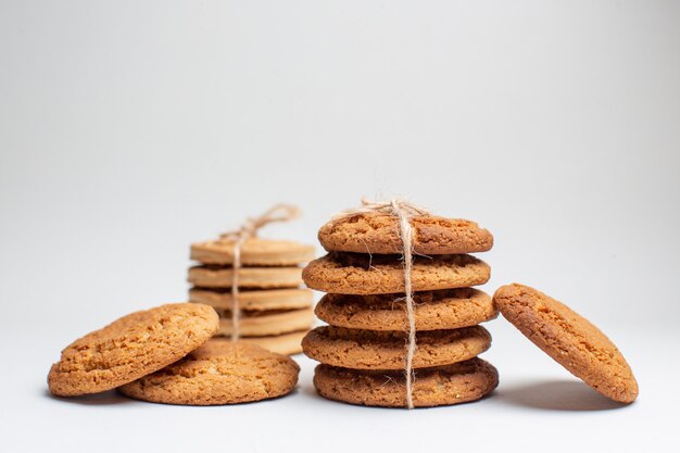 Vista frontal de galletas dulces en galletas blancas pastel de fotos de té de azúcar