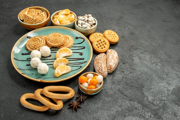 Vista frontal de galletas dulces con galletas y caramelos en la mesa gris galleta de galleta dulce