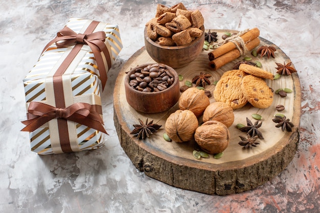 Vista frontal de galletas dulces con regalos y nueces sobre fondo claro color de té de azúcar cookie dulce pastel de cacao amor