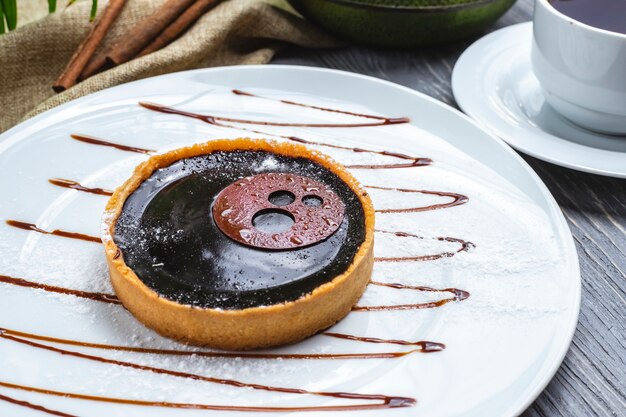 Vista frontal de galletas de postre con glaseado de chocolate en un plato