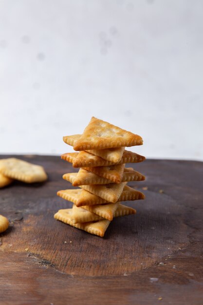 Vista frontal de galletas saladas forradas en un escritorio de madera