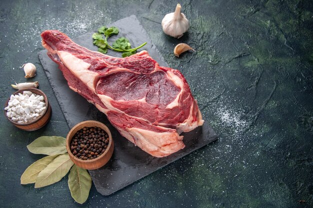 Vista frontal de gran rebanada de carne carne cruda con pimienta en comida de animal oscura foto comida de pollo carnicero de barbacoa