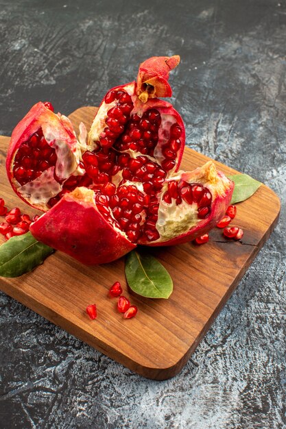 Vista frontal granadas en rodajas frutas rojas frescas en la mesa de luz fruta roja fresca
