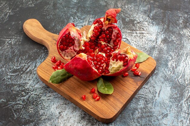 Vista frontal de granadas en rodajas frutas rojas frescas en mesa de luz fruta roja fresca