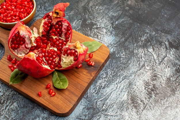 Vista frontal granadas en rodajas frutas rojas frescas en la mesa oscura baya roja fresca