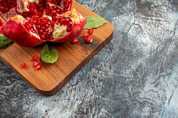 Vista frontal de granadas en rodajas frutos rojos frescos en la mesa de luz