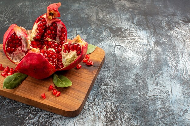 Vista frontal de granadas en rodajas frutos rojos frescos en la mesa de luz