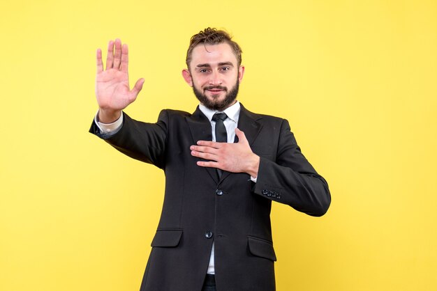 Vista frontal de la gratitud del empresario joven en amarillo