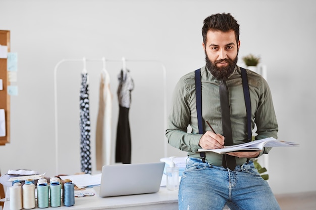 Foto gratuita vista frontal del guapo diseñador de moda masculino en atelier