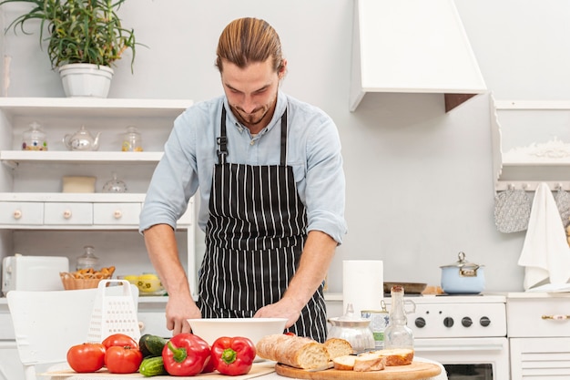 Vista frontal guapo joven cocinando