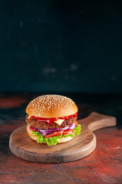 Vista frontal hamburguesa con queso de carne deliciosa en superficie oscura