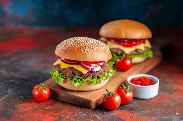 Vista frontal hamburguesa con queso de carne deliciosa en la tabla de cortar oscura