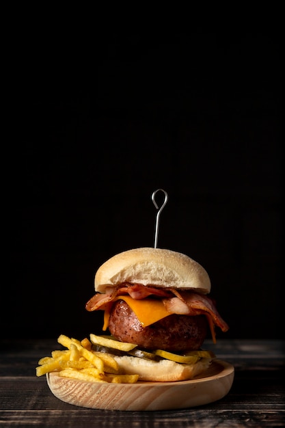Vista frontal de una hamburguesa con queso y papas fritas con espacio de copia