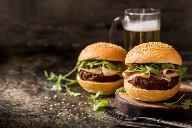 Vista frontal hamburguesas de carne fresca con tocino y cerveza