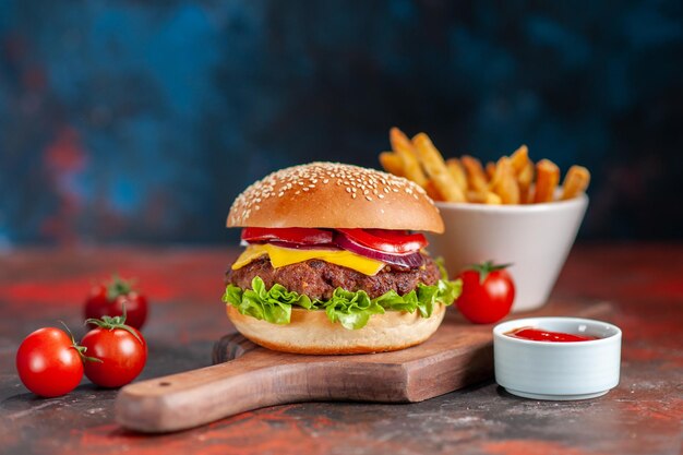 Vista frontal hamburguesas con queso de carne deliciosa con tomates rojos en la oscuridad