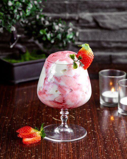 Vista frontal helado con mermelada de fresa en un vaso y rodajas de fresa