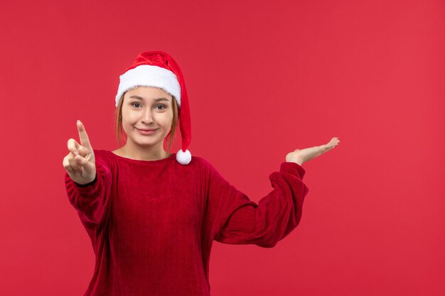 Vista frontal hembra joven mostrando número, rojo vacaciones navidad