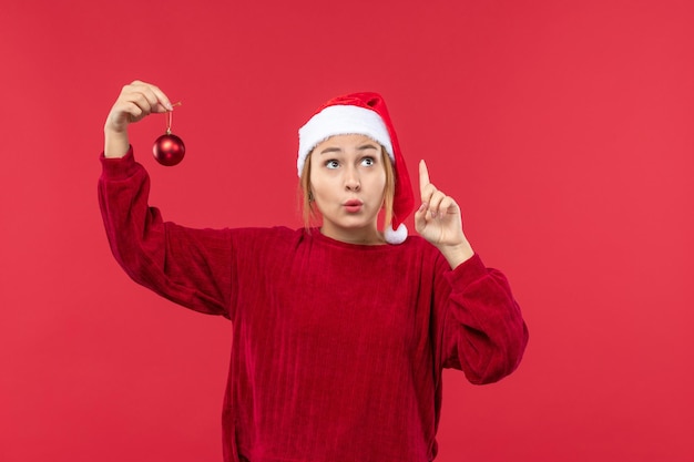 Vista frontal hembra regular sosteniendo un juguete de navidad, vacaciones de navidad de emoción